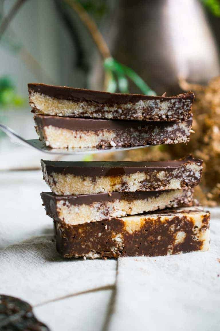 Coconut caramel slices stacked on a plate.