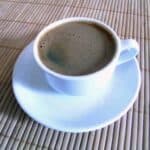 Bulletproof coffee in white cup on table.