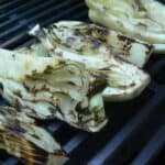 Grilled fennel on a grill grate.
