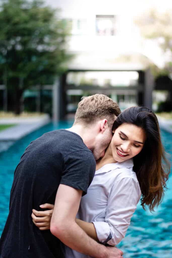 Fertility Awareness Method: Couple embrace, man biting womans neck.