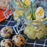 Egg salad in jars on a table with eggs