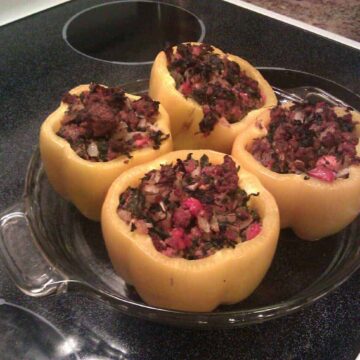 paleo stuffed peppers in a pie plate on stove top