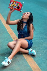woman pouring fruit loops into her mouth from the box sitting in the middle of the road - Common Dieting Mindset Mistakes