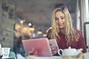 macro tracking apps - woman in red sweater at restarant looking at her phone