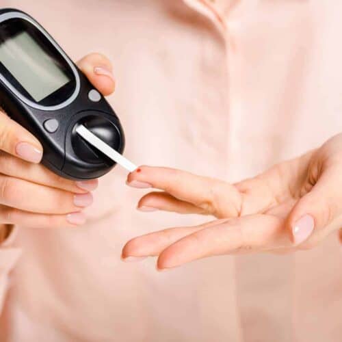 Woman Using a Blood Glucose Ketone Meter