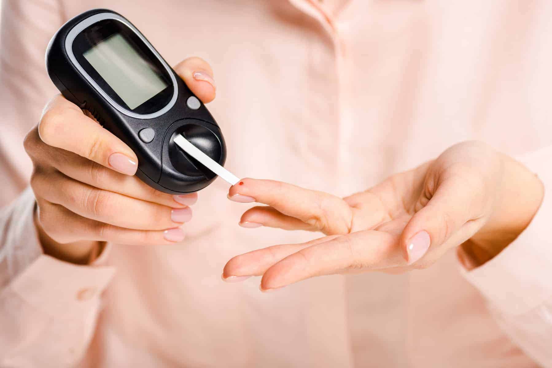 Woman Using a Blood Glucose Ketone Meter