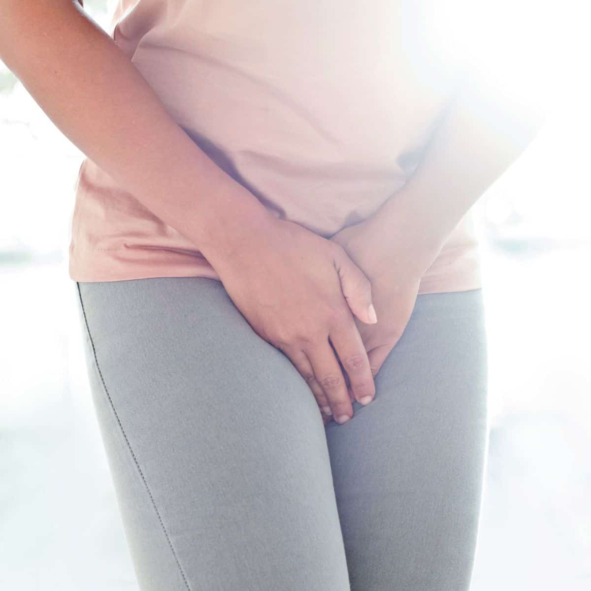 Woman holding her vulva in pain.