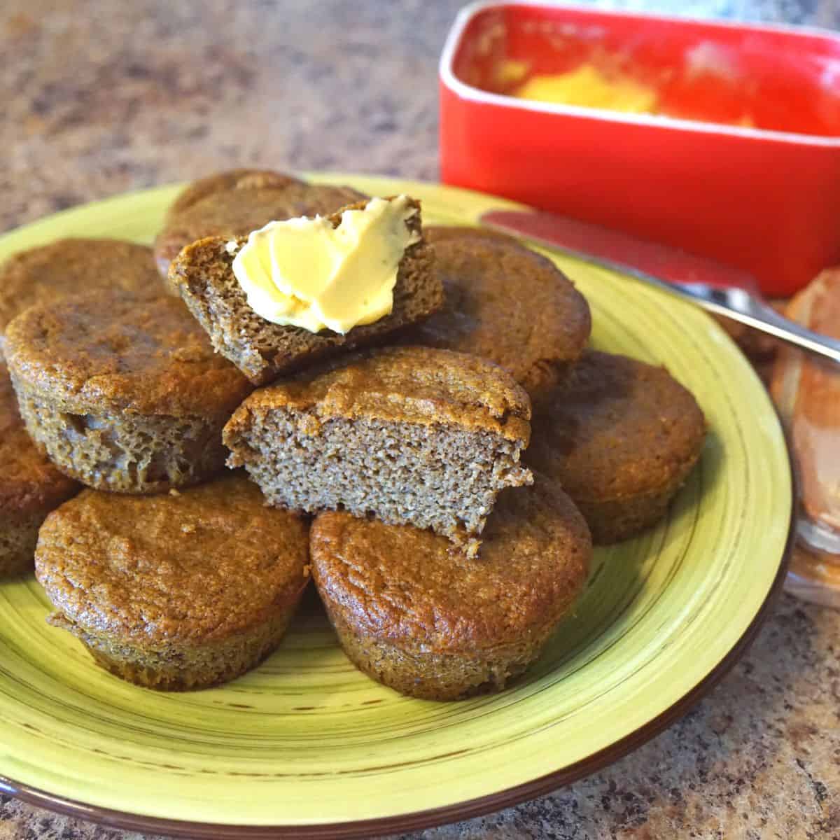 Keto Pumpkin Spice Muffins Stacked and Topped With Butter