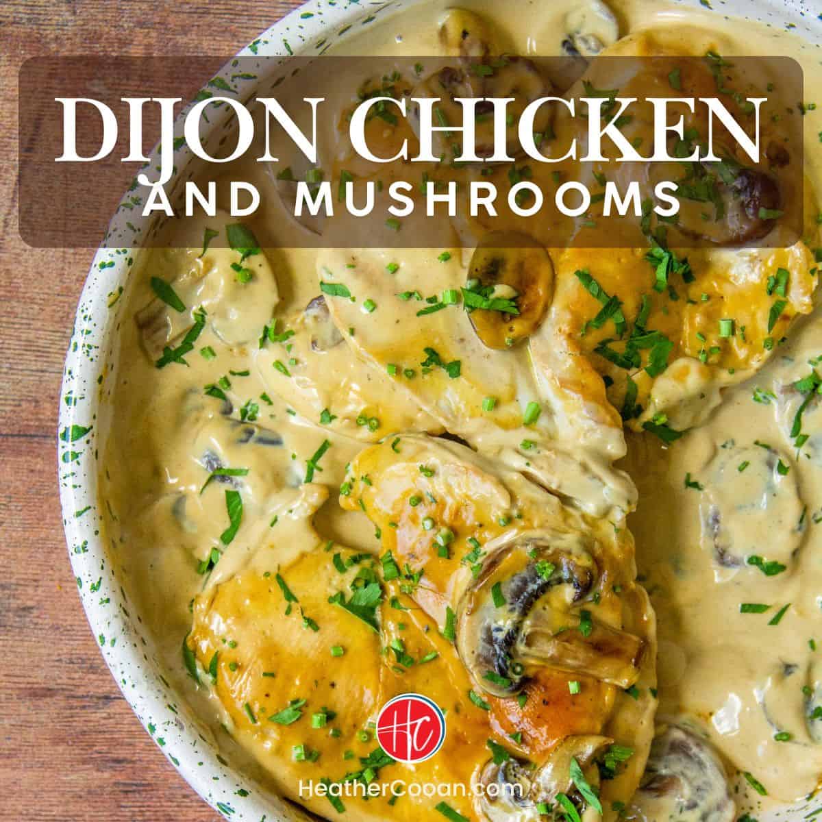 Chicken and mushrooms in creamy Dijon sauce, garnished with parsley, served in a speckled ceramic dish.